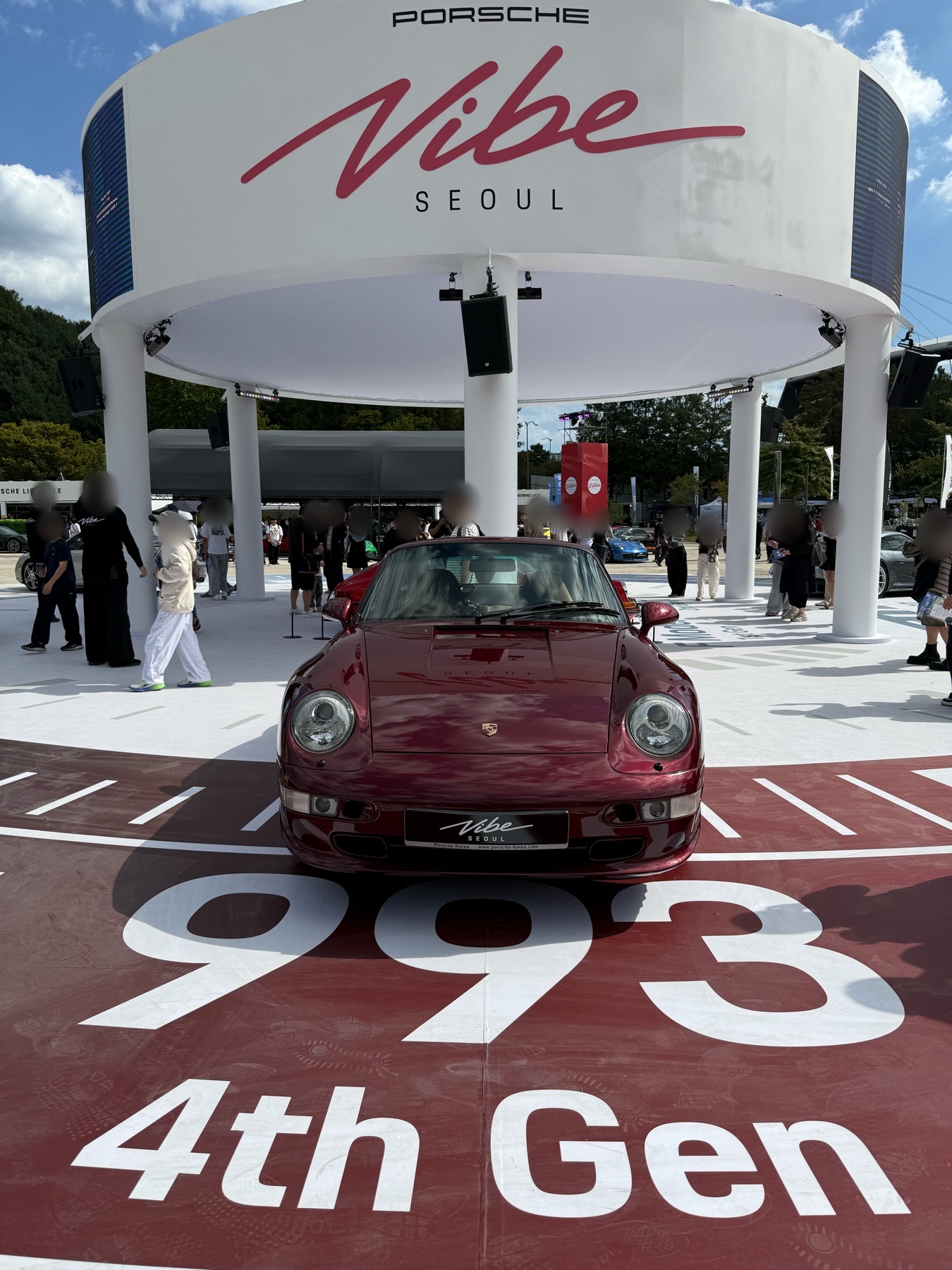 PORSCHE Vibe SEOUL 간판 아래의 버건디색 전시 차량과 바닥의 993, 4th Gen 표기.