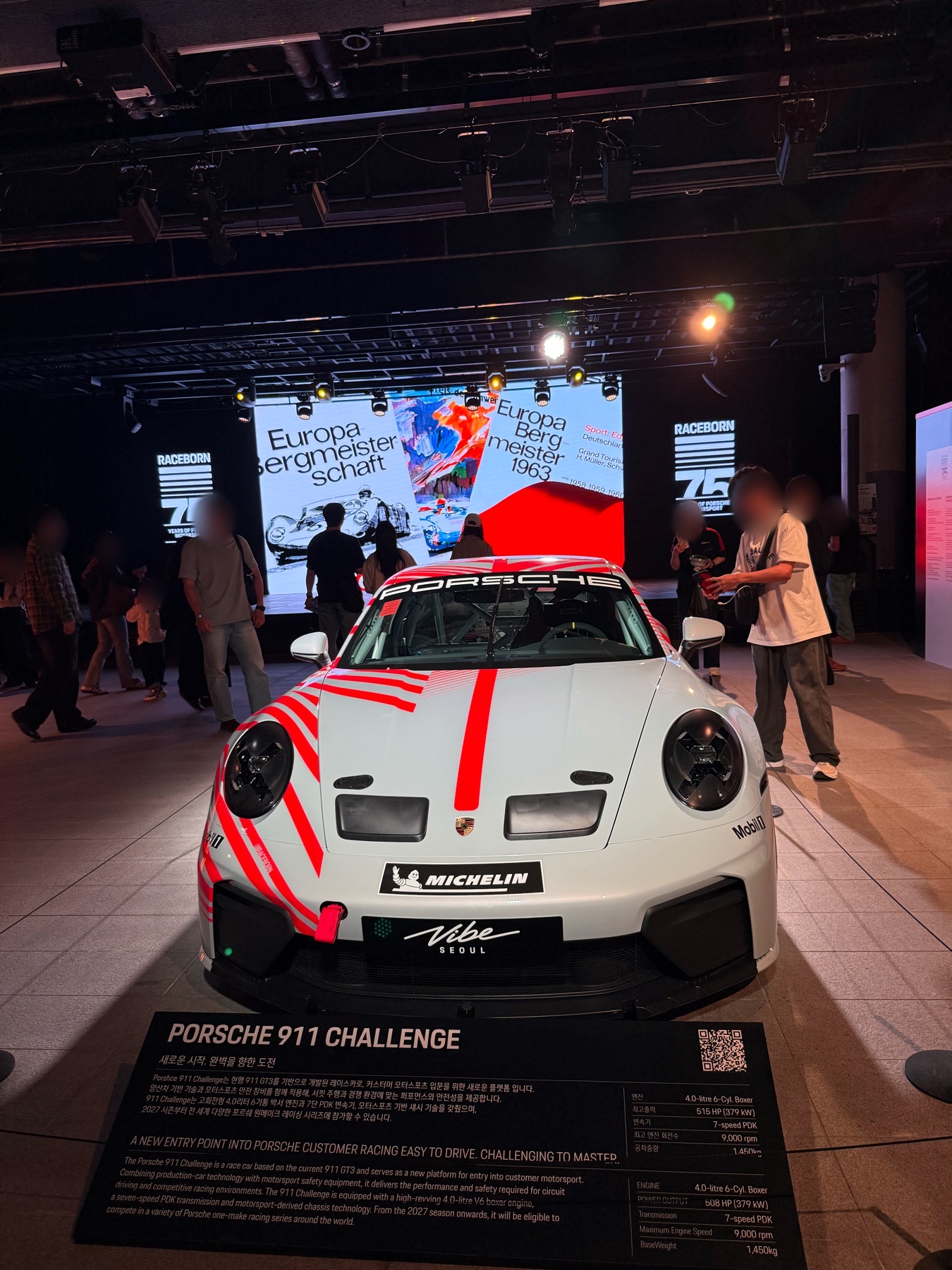 PORSCHE 911 CHALLENGE 안내판 뒤의 흰색·붉은색 전시 차량 정면.